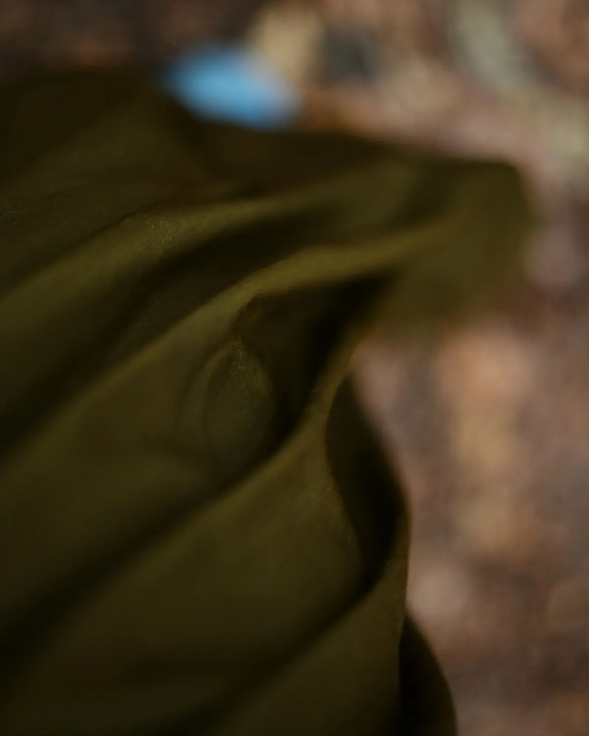 Dark cloth falling in deep folds, caught against shadow.