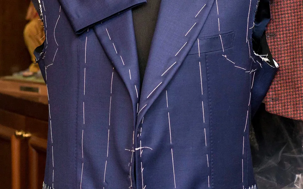 A dark button-through shirt laid flat against a muted ground.